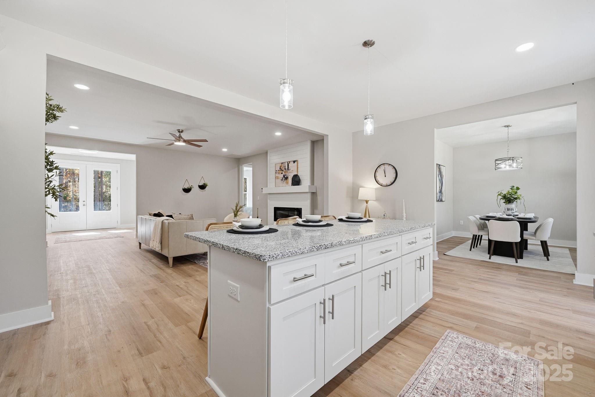 295 Mainsail Road Salisbury, NC 28146 - Photo 16 of 42 a large white kitchen with a stove a sink dishwasher and a dining table with wooden floor