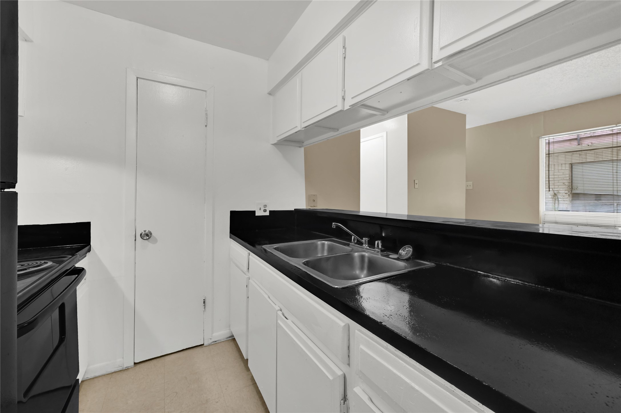 7211 Atwell Drive, Unit 16 Houston, TX 77081 - Photo 11 of 19 a kitchen with a sink and a refrigerator