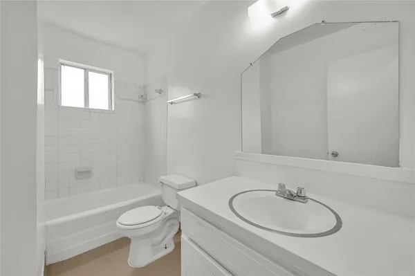 a bathroom with a granite countertop toilet sink and mirror