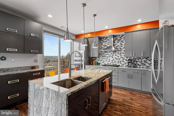 a kitchen with stainless steel appliances granite countertop a sink stove and refrigerator
