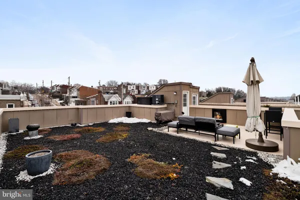 a terrace of a house with couches potted plants and sky view
