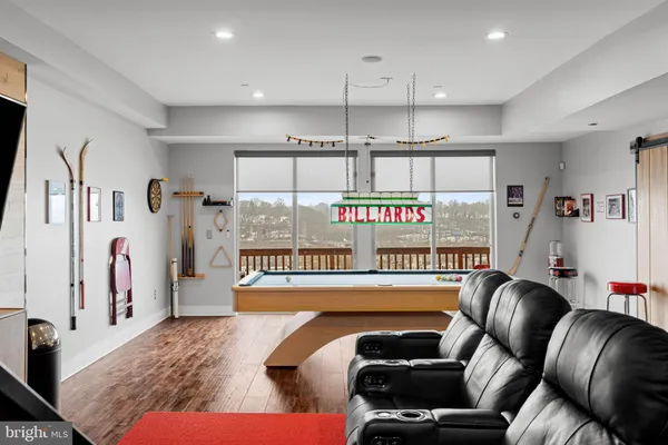 a room with pool table and wooden floor