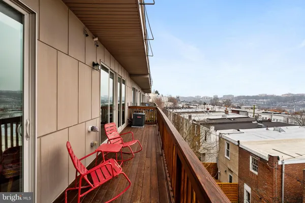 a balcony with wooden floor and city view