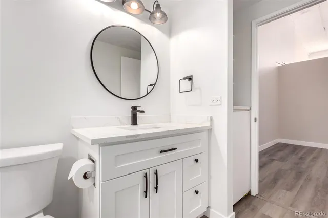 a bathroom with a sink mirror vanity and toilet