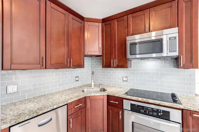 a kitchen with stainless steel appliances granite countertop a sink stove and microwave