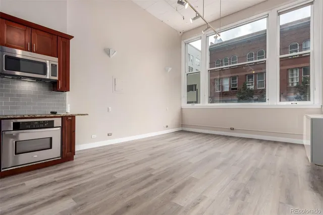 a view of a kitchen with wooden floor and stainless steel appliances