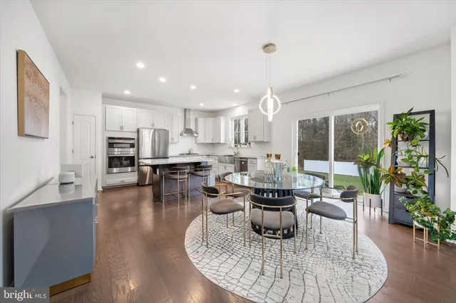 a living room with furniture a potted plant and a wooden floor
