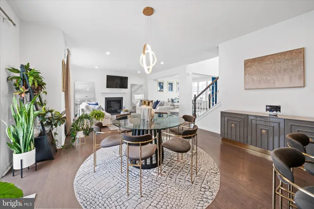 a kitchen with stainless steel appliances granite countertop a sink dishwasher a refrigerator and white cabinets with wooden floor