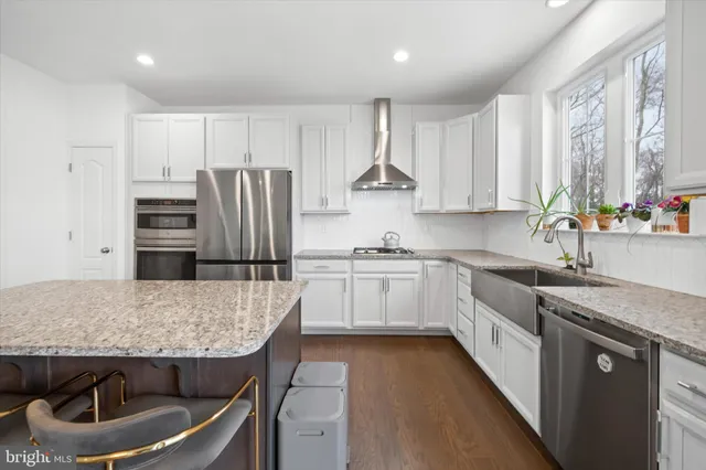 a kitchen with granite countertop a refrigerator stove and sink