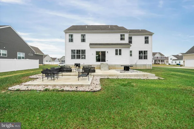 a view of a white house with a big yard and large trees