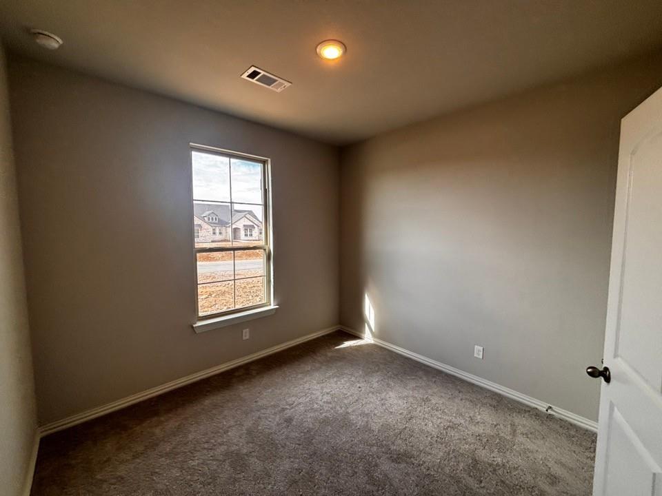 128 Pheasant Run Drive Rhome, TX 76078 - Photo 11 of 14 Neutral wall finishes, recessed ceiling lighting, and dark carpet flooring