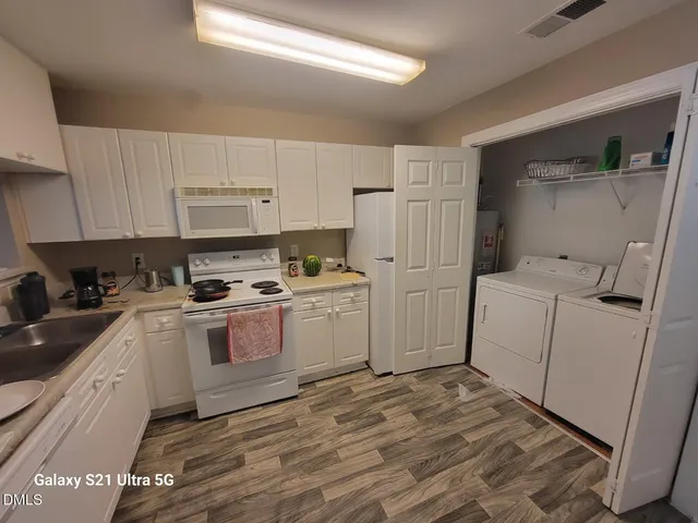 a kitchen with a sink a refrigerator and cabinets