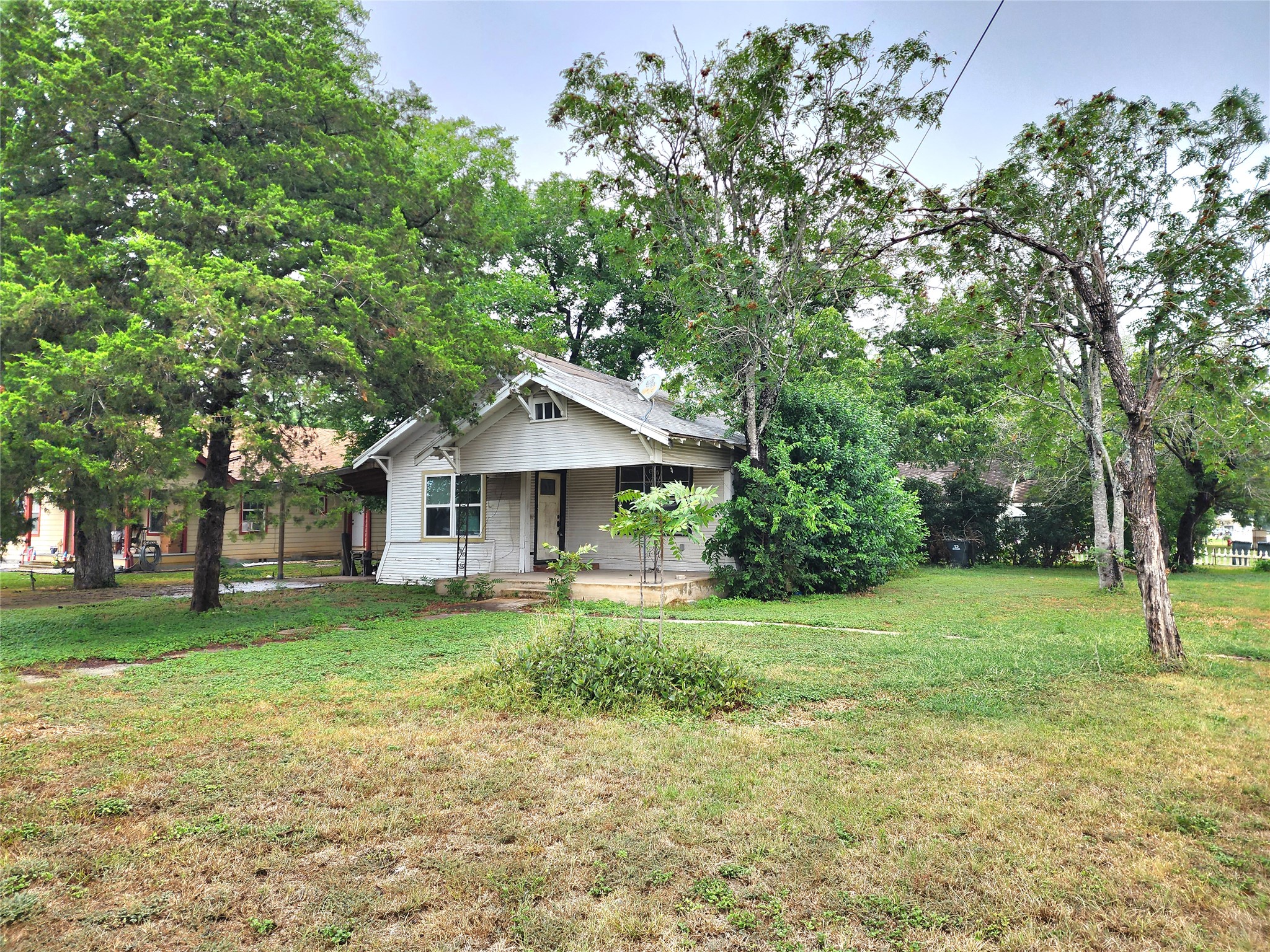 123 East Davis Street Luling, TX 78648 - Photo 5 of 14 A classic facade with a welcoming porch is nestled among mature trees on a generous green lot.