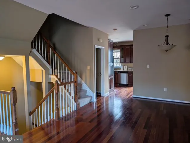 a view of a hallway with wooden floor and staircase