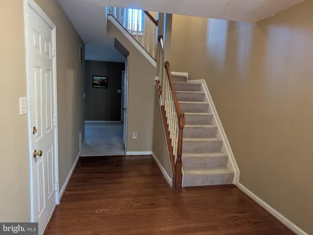 a view of a hallway with wooden floor and entryway
