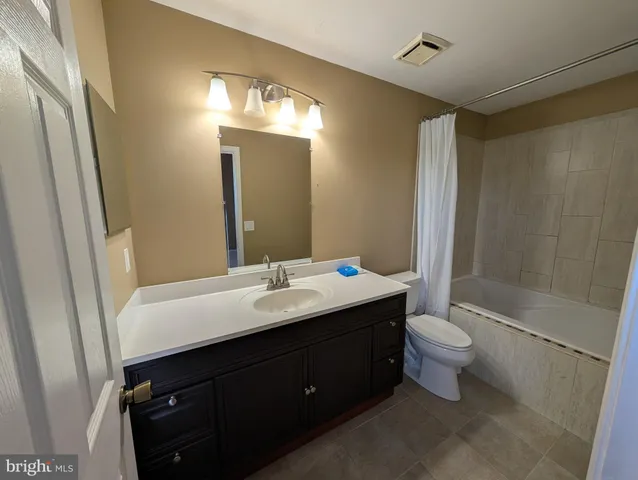 a bathroom with a double vanity sink mirror and toilet
