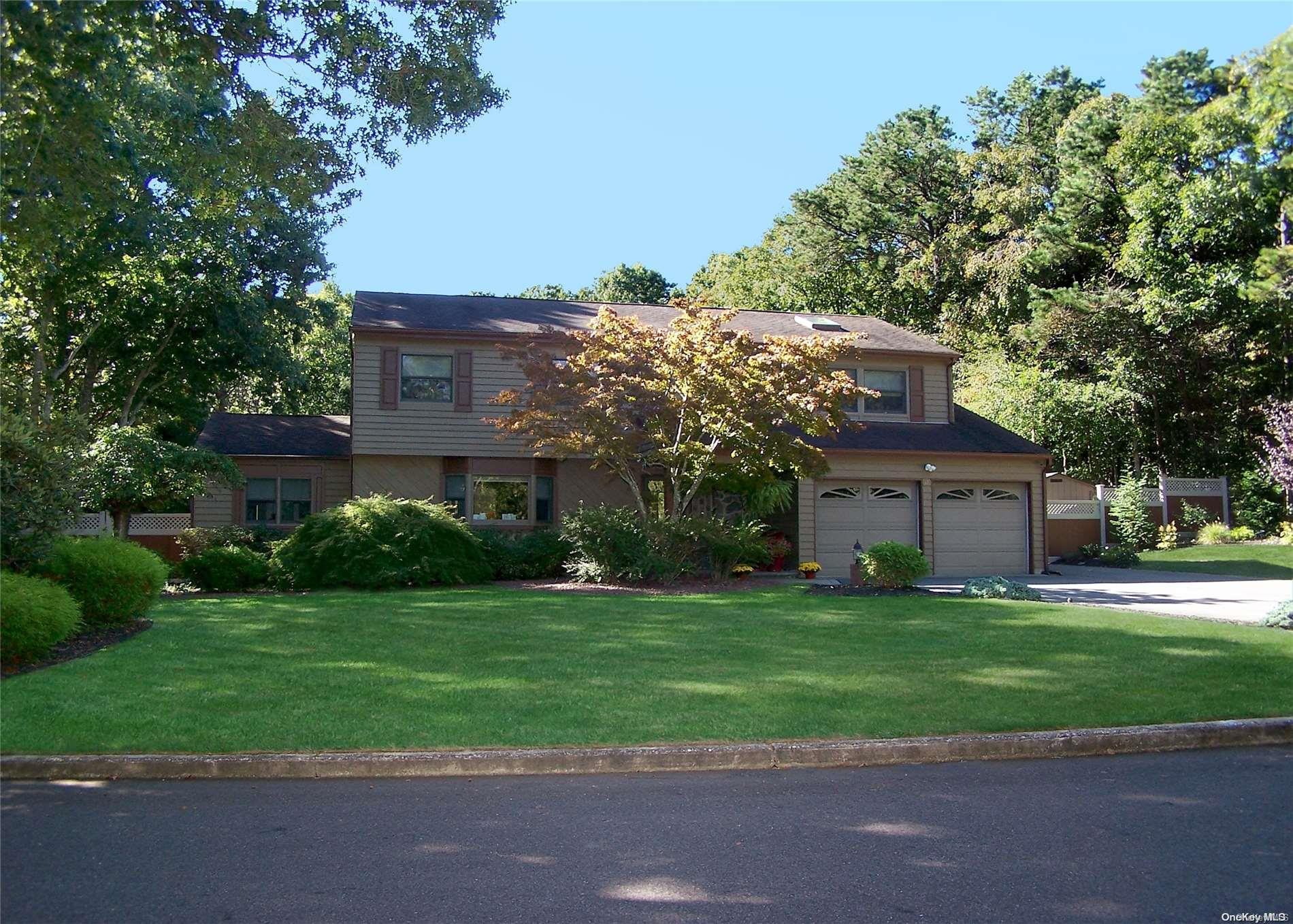 4 Watermill Way Ridge, NY 11961 - Photo 1 of 1 a front view of a house with a yard and trees