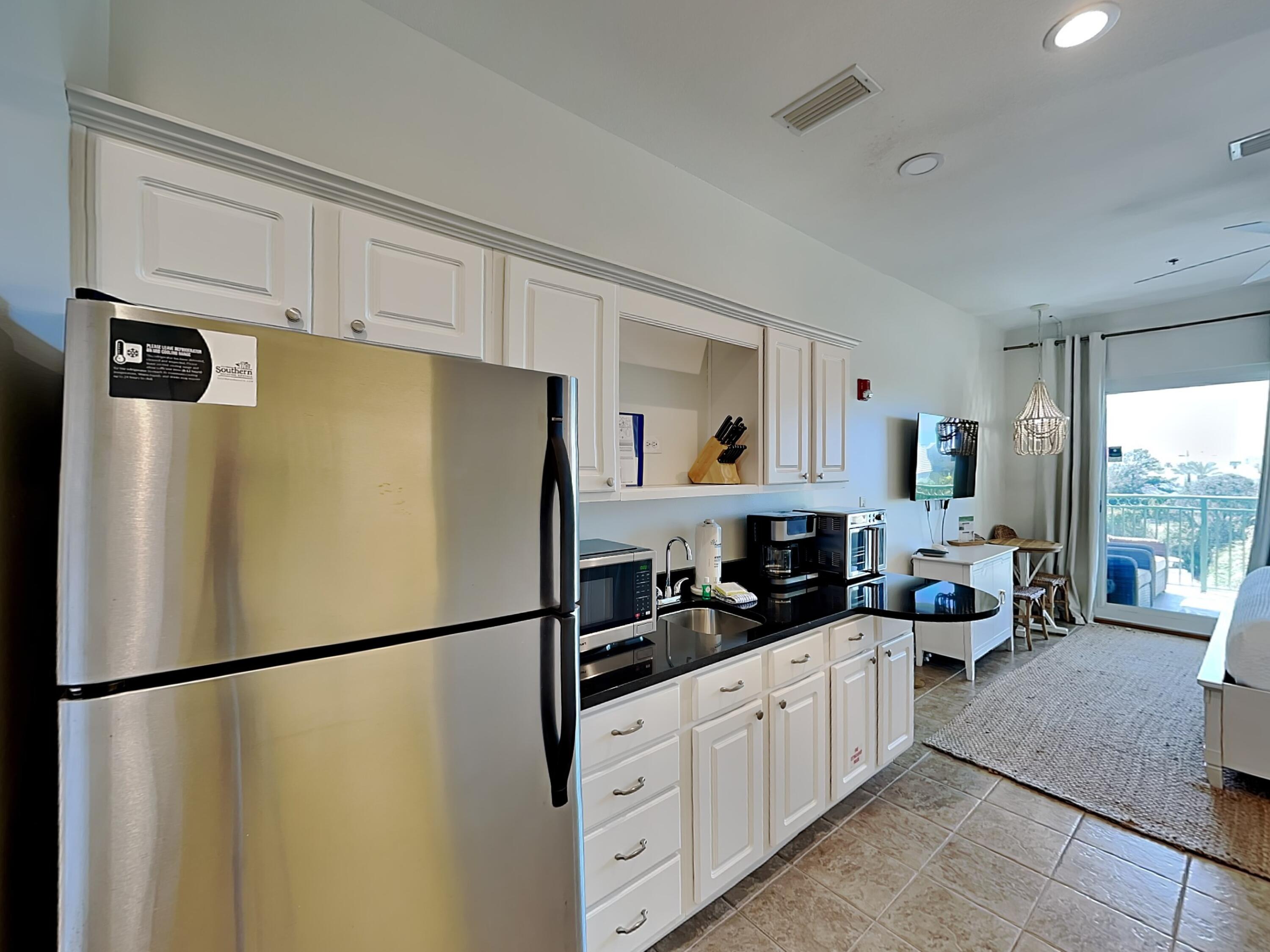 9955 East County Highway 30A, Unit 303 Inlet Beach, FL 32461 - Photo 5 of 17 a kitchen with stainless steel appliances a refrigerator a white cabinets and a refrigerator