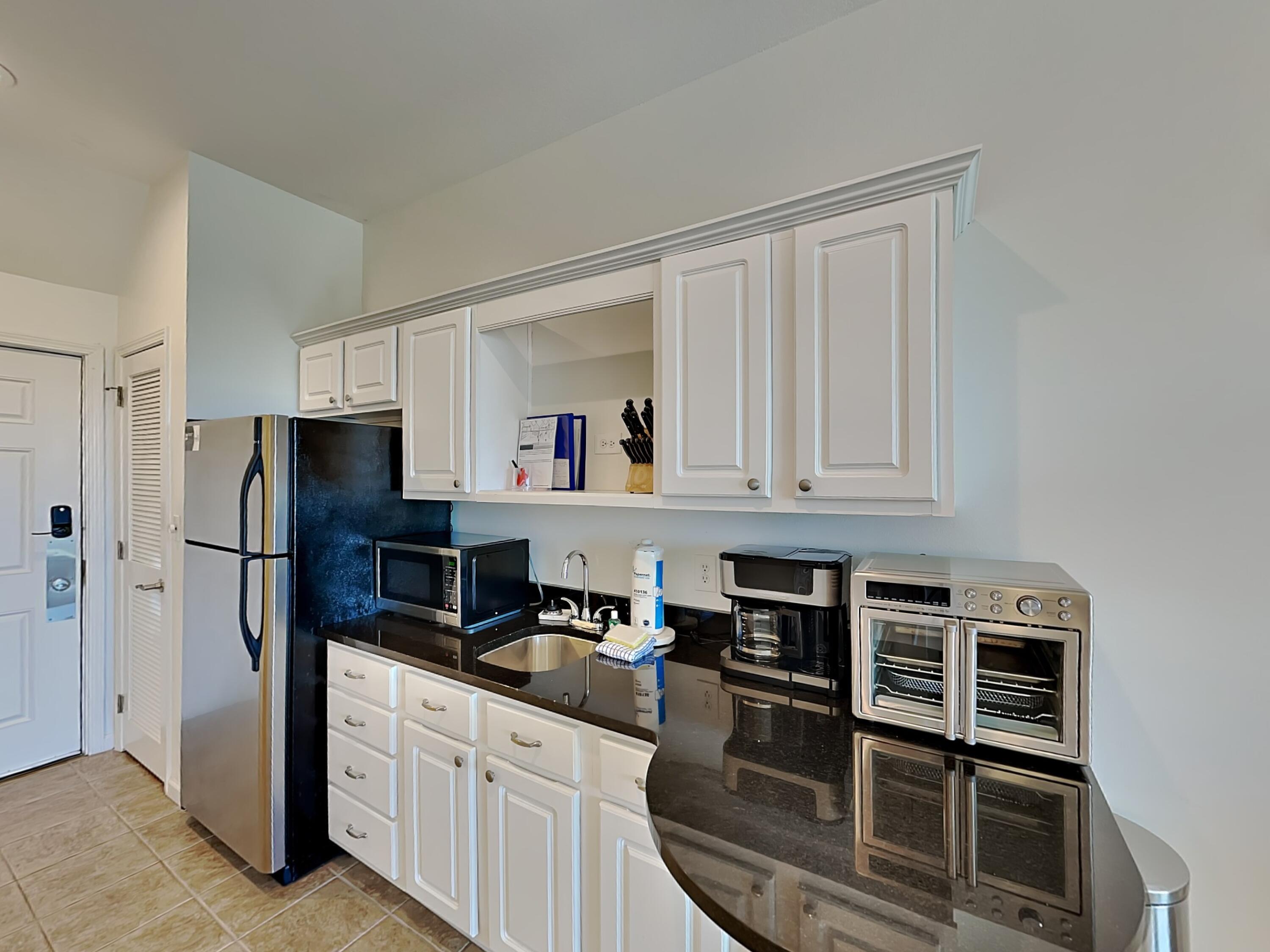 9955 East County Highway 30A, Unit 303 Inlet Beach, FL 32461 - Photo 7 of 17 a kitchen with stainless steel appliances a refrigerator sink and cabinets