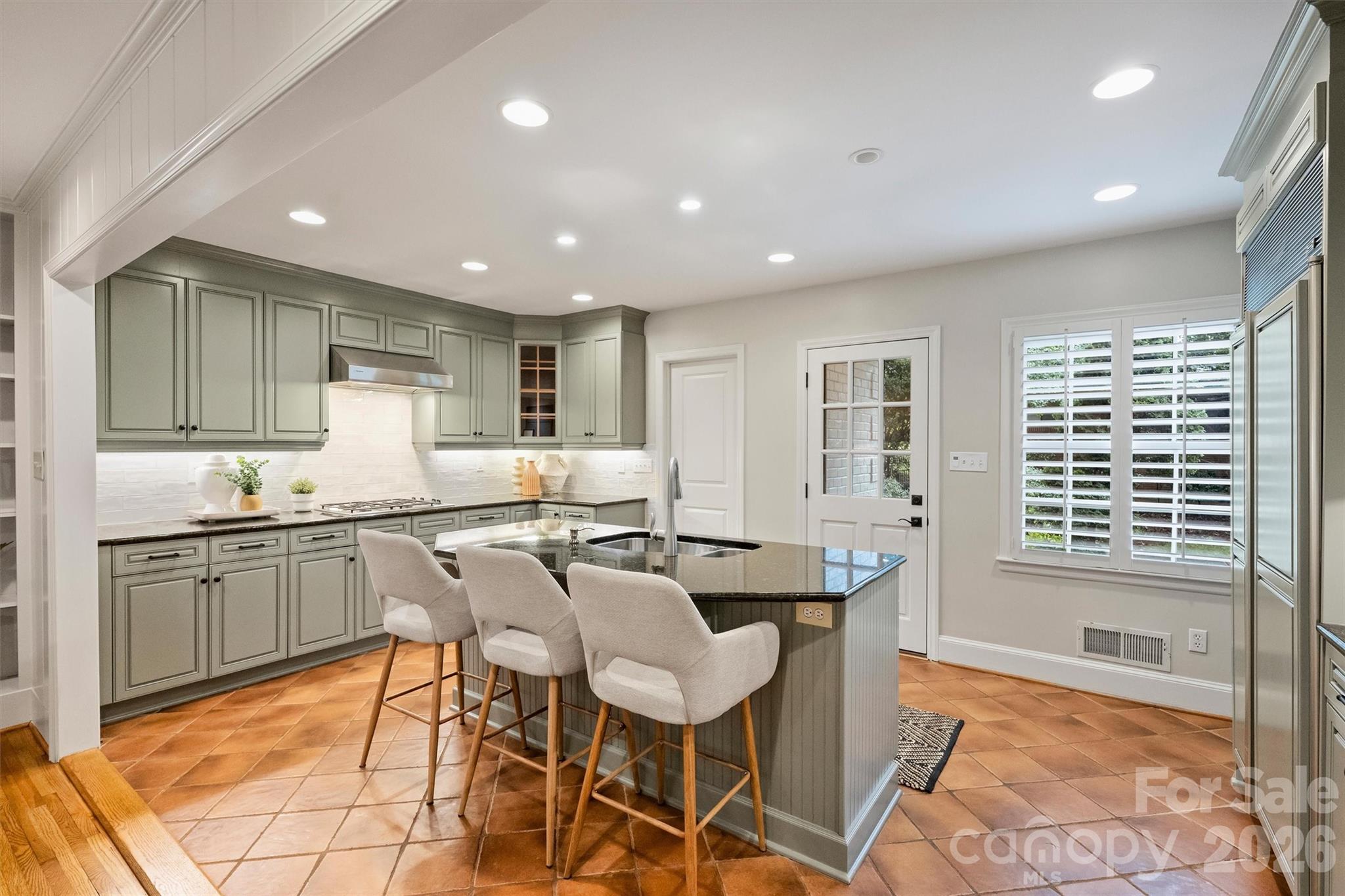 5519 Robinhood Road Charlotte, NC 28211 - Photo 15 of 46 a kitchen with granite countertop kitchen island stainless steel appliances a table and chairs in it