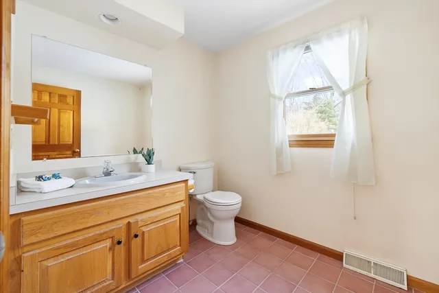 a bathroom with a sink a toilet and a window