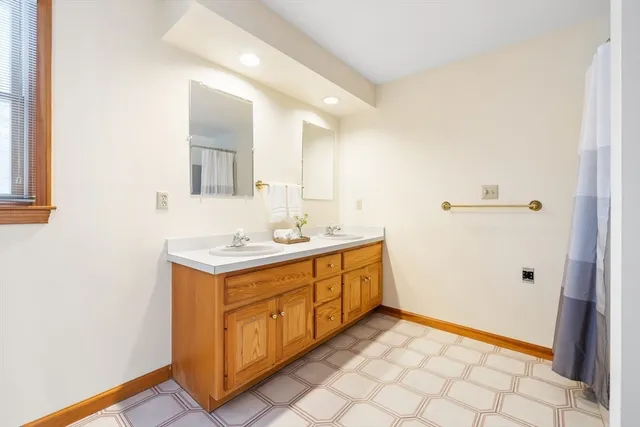 a bathroom with a toilet a window and shower