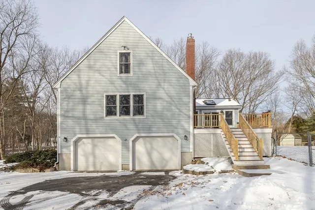 a view of a white house with a yard covered in snow