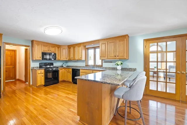 a kitchen with granite countertop wooden cabinets a counter top space and stainless steel appliances