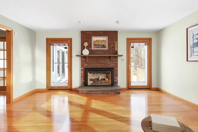 a view of a livingroom with wooden floor and a fireplace