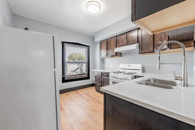 a kitchen with stainless steel appliances granite countertop a sink stove and cabinets