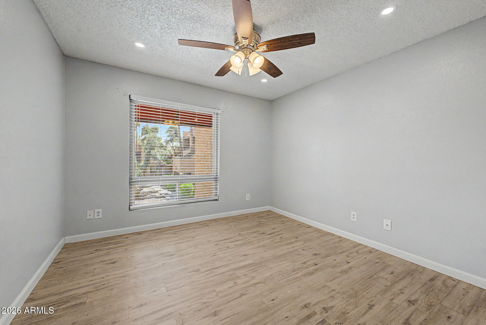 2625 East Indian School Road, Unit 227 Phoenix, AZ 85016 - Photo 12 of 31 an empty room with wooden floor and windows
