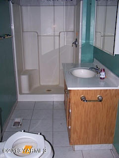 3900 Progressive Road Wapato, WA 98951 - Photo 13 of 14 a bathroom with a granite countertop sink a mirror and shower