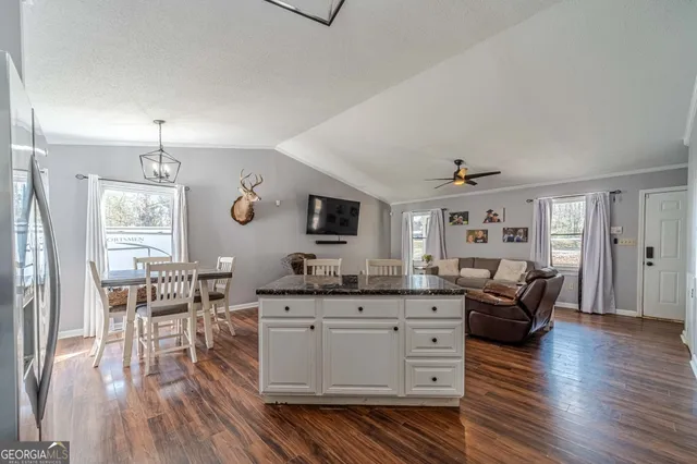 a outdoor kitchen with kitchen island a large window a sink and appliances