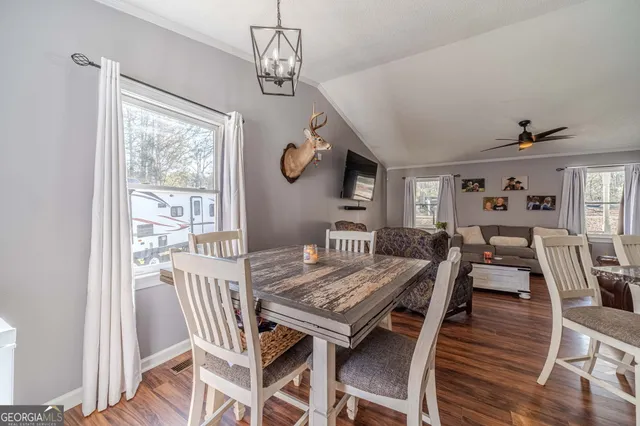 a kitchen with stainless steel appliances granite countertop a sink a stove a refrigerator cabinets and chairs