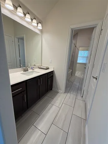 a bathroom with a sink vanity and a mirror