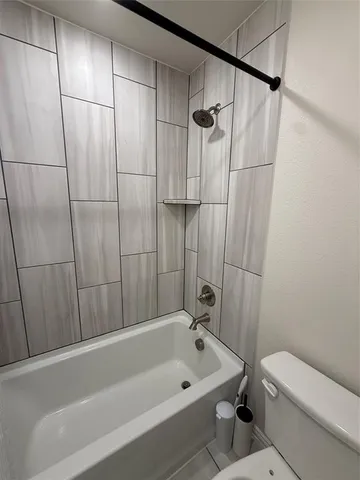 a bathroom with a bathtub a toilet and a shower