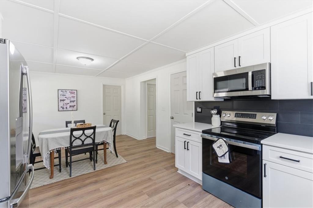 344 Colbert Road Dallas, GA 30132 - Photo 11 of 29 a kitchen with stainless steel appliances a stove a sink dishwasher a microwave oven with cabinets and wooden floor