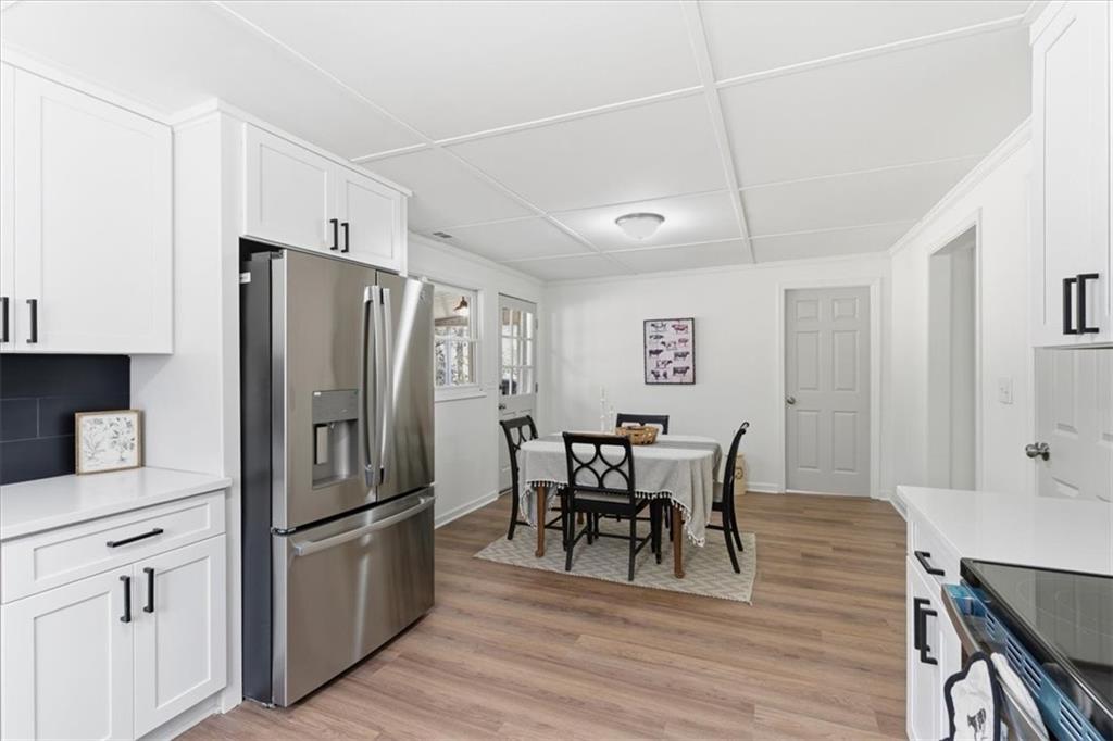 344 Colbert Road Dallas, GA 30132 - Photo 12 of 29 a kitchen with stainless steel appliances a refrigerator a stove a dining table and chairs with wooden floor