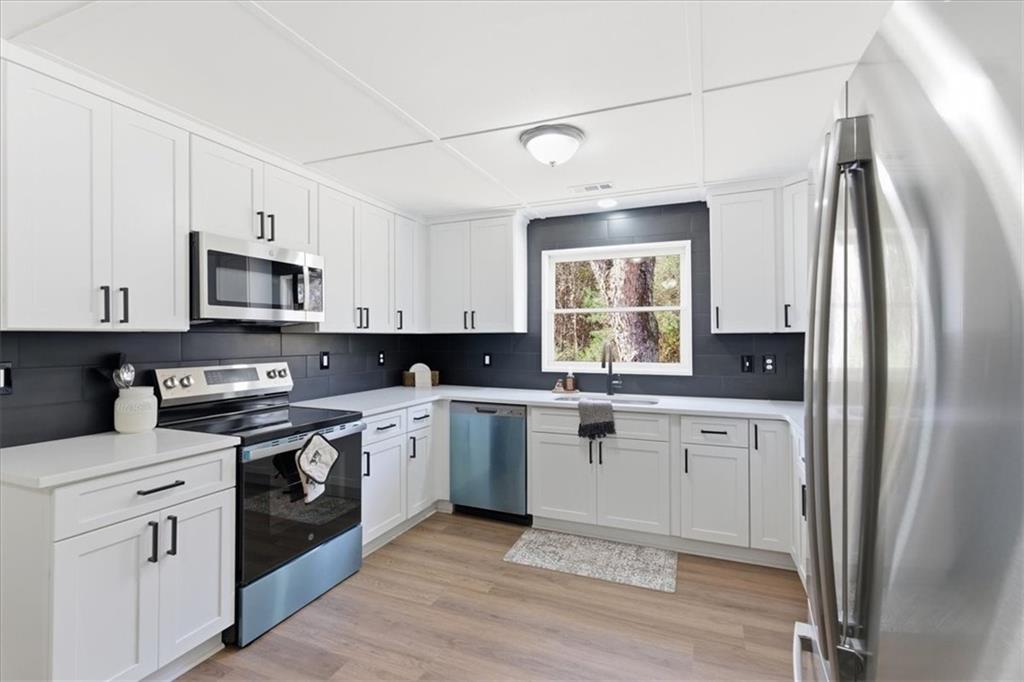 344 Colbert Road Dallas, GA 30132 - Photo 10 of 29 a kitchen with stainless steel appliances granite countertop a stove a sink and a refrigerator