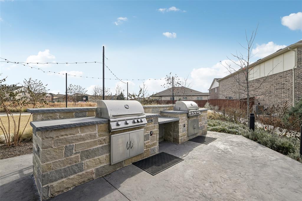 4430 Prairie Crossing Prosper, TX 75078 - Photo 7 of 15 Outdoor grilling station featuring two stainless steel grills built into stone bases, with counter space