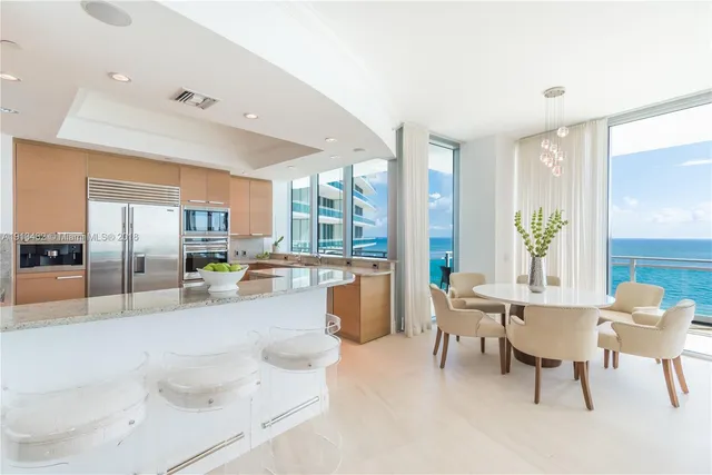 a large white kitchen with a large window and stainless steel appliances