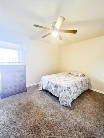 a bedroom with a bed and ceiling fan