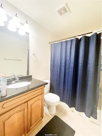 a bathroom with a granite countertop sink toilet and shower