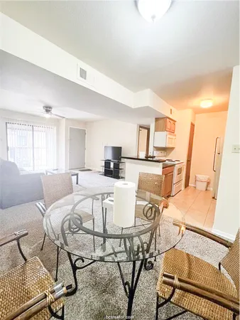 a view of a dining room with furniture a rug and wooden floor