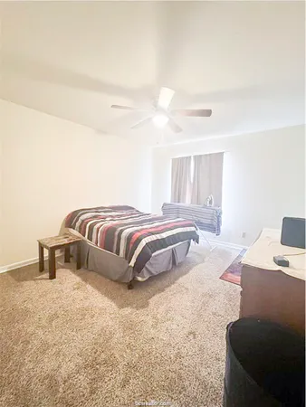 a spacious bedroom with a bed and a cabinets