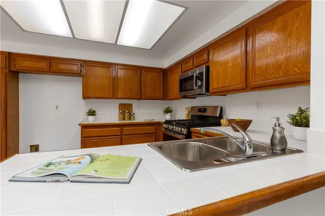 a kitchen with stainless steel appliances granite countertop a sink a stove and cabinets