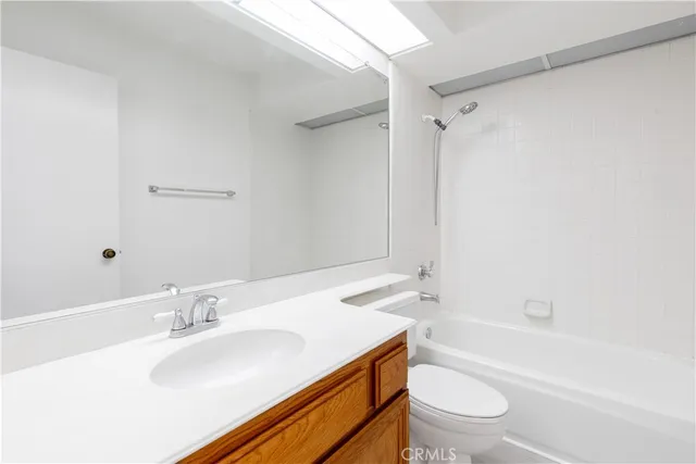 a bathroom with a sink toilet vanity and shower