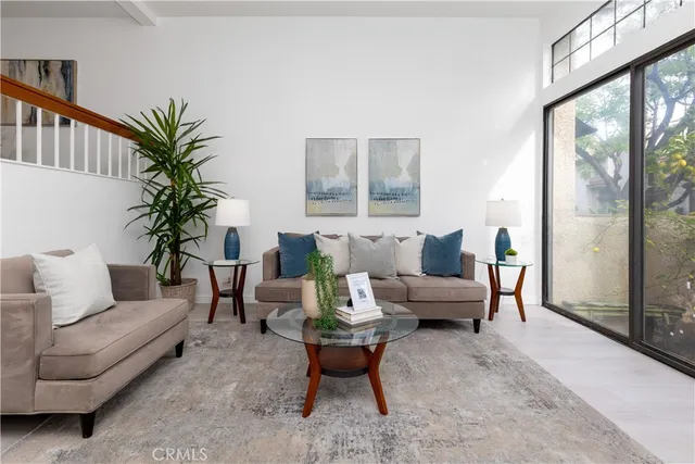 a living room with furniture a large window and a potted plant