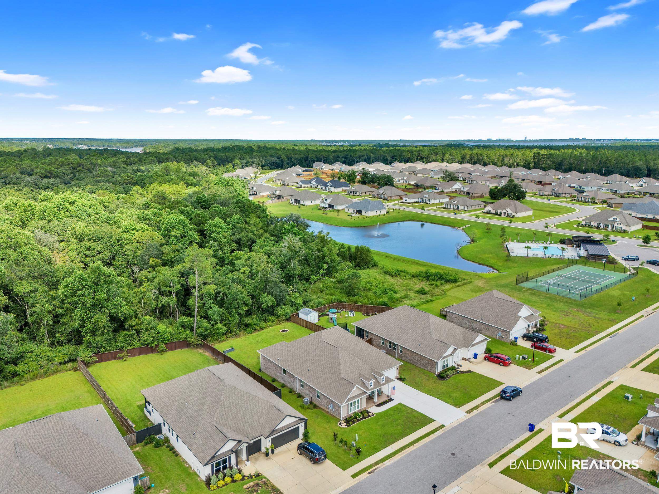 8774 Primland Boulevard Foley, AL 36535 - Photo 46 of 49 Aerial view of residential area with a large body of water and a heavily wooded area