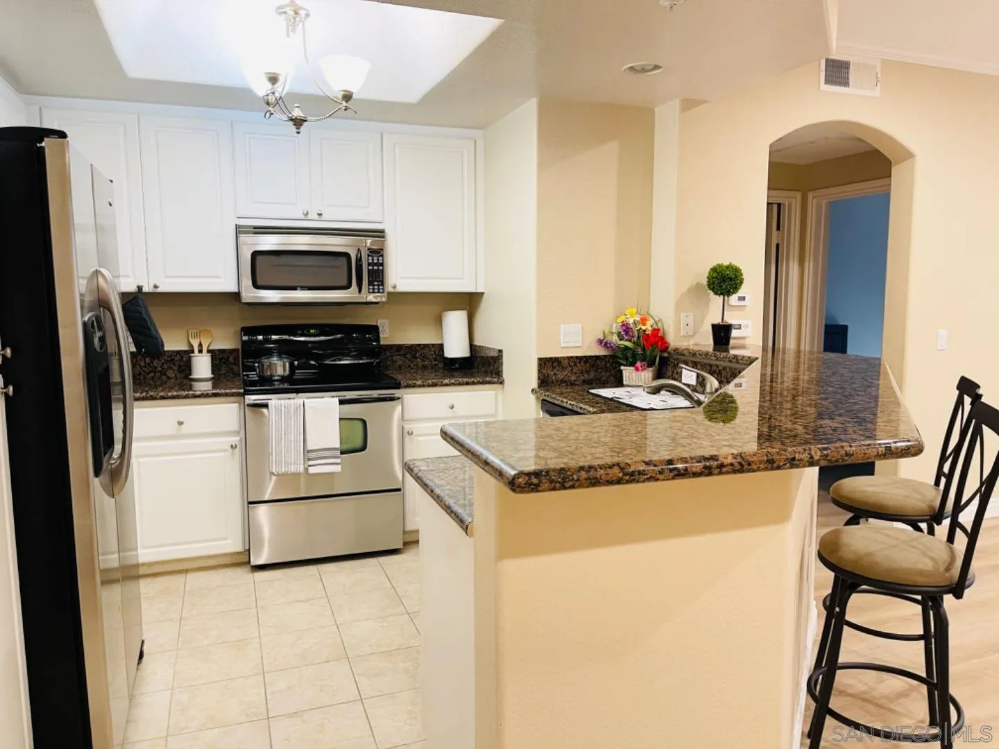 4155 Executive Drive, Unit E210 San Diego, CA 92037 - Photo 11 of 12 a kitchen with granite countertop a sink appliances and cabinets